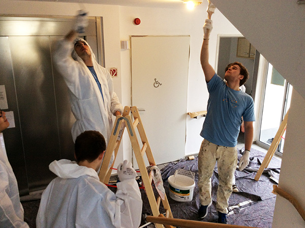 RWE-Mitarbeiter helfen beim Renovieren des Treppenhauses von Pro Mobil